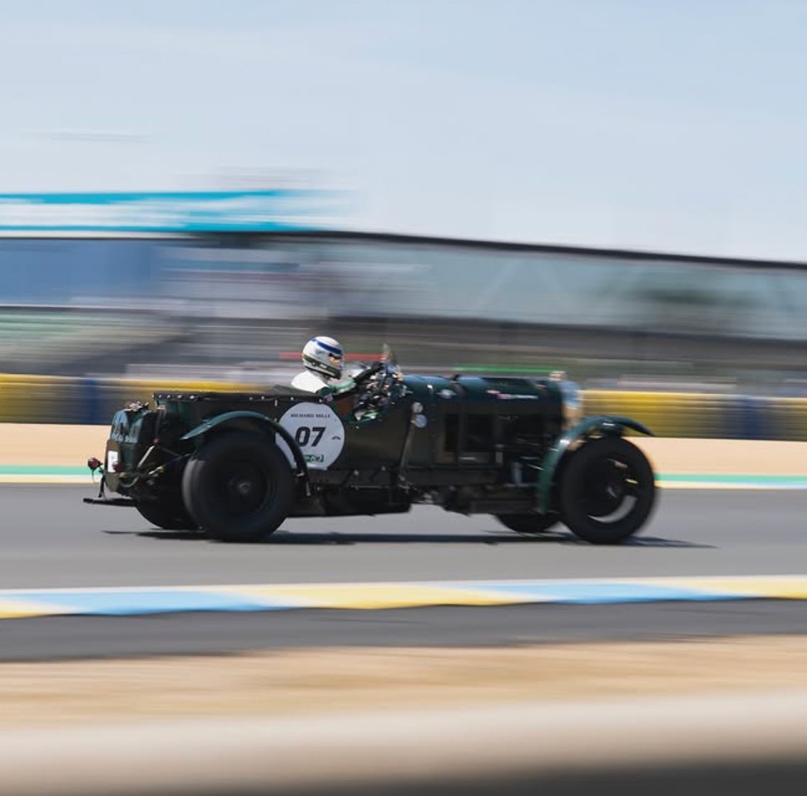 A vintage green Bentley racing car on a track